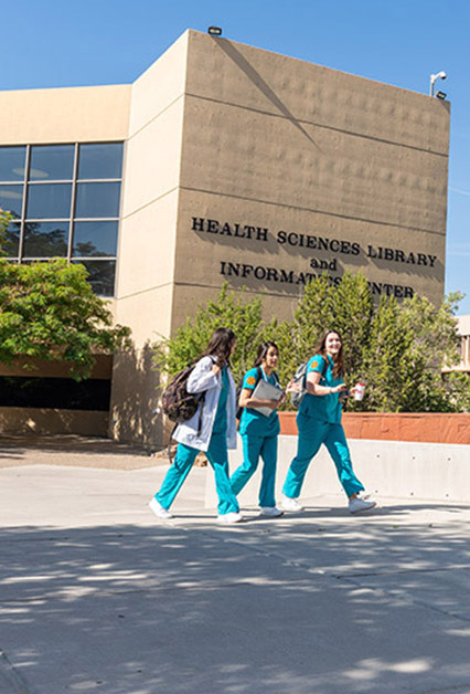Three students walking through UNM HSC campus