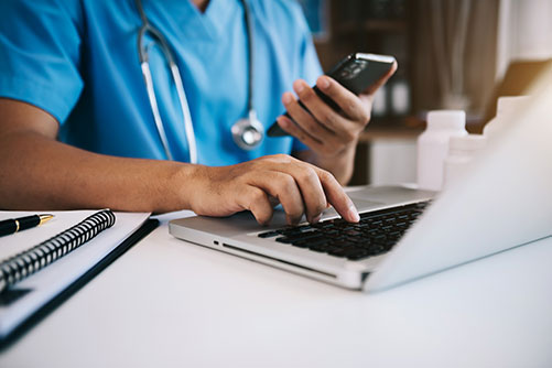 a doctor at a computer about to make a call