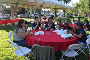 Student eating around a table at the BBQ.