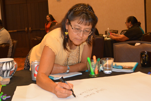 Woman writing at table during CHAW.