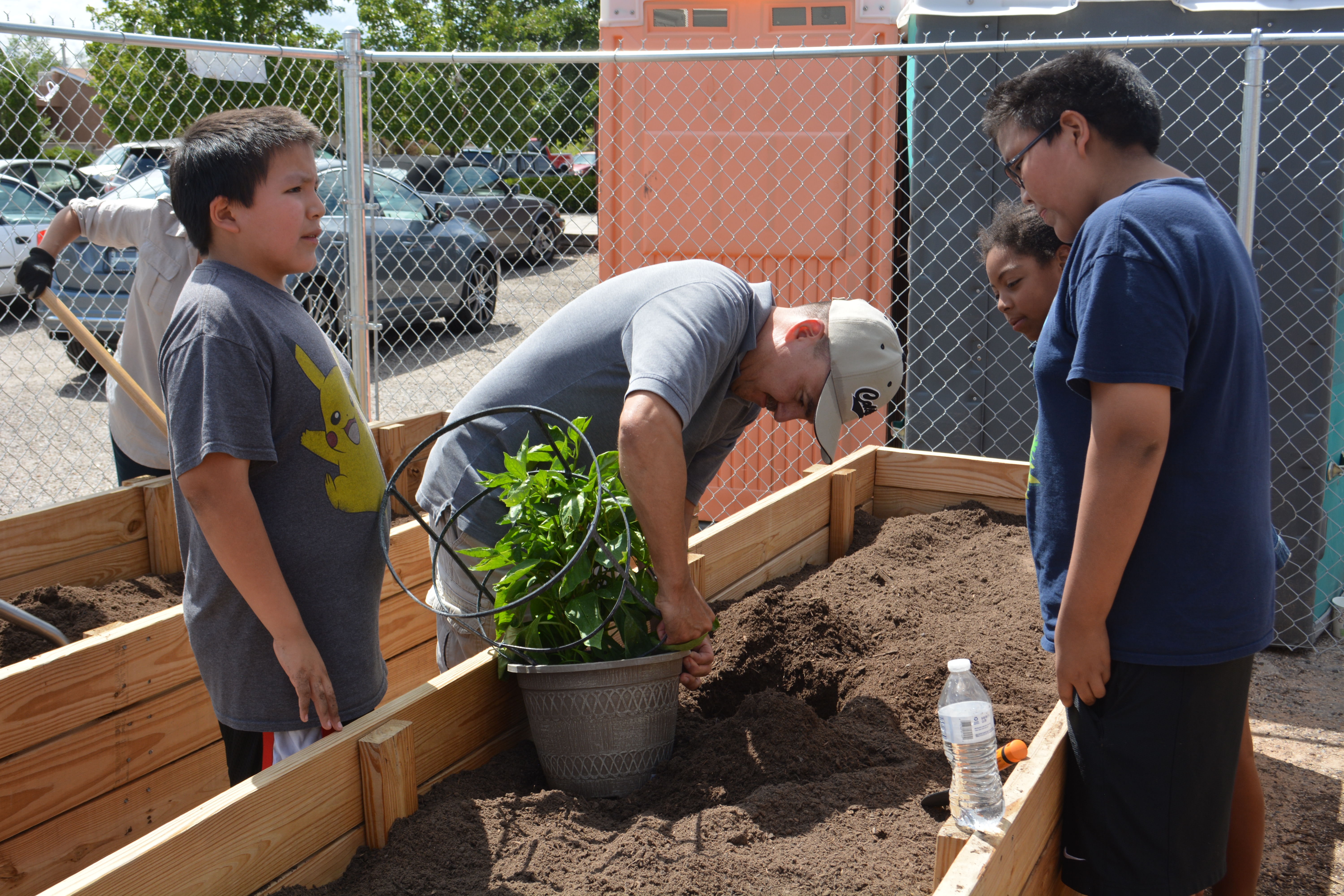 Des adolescents aident à planter une plante.