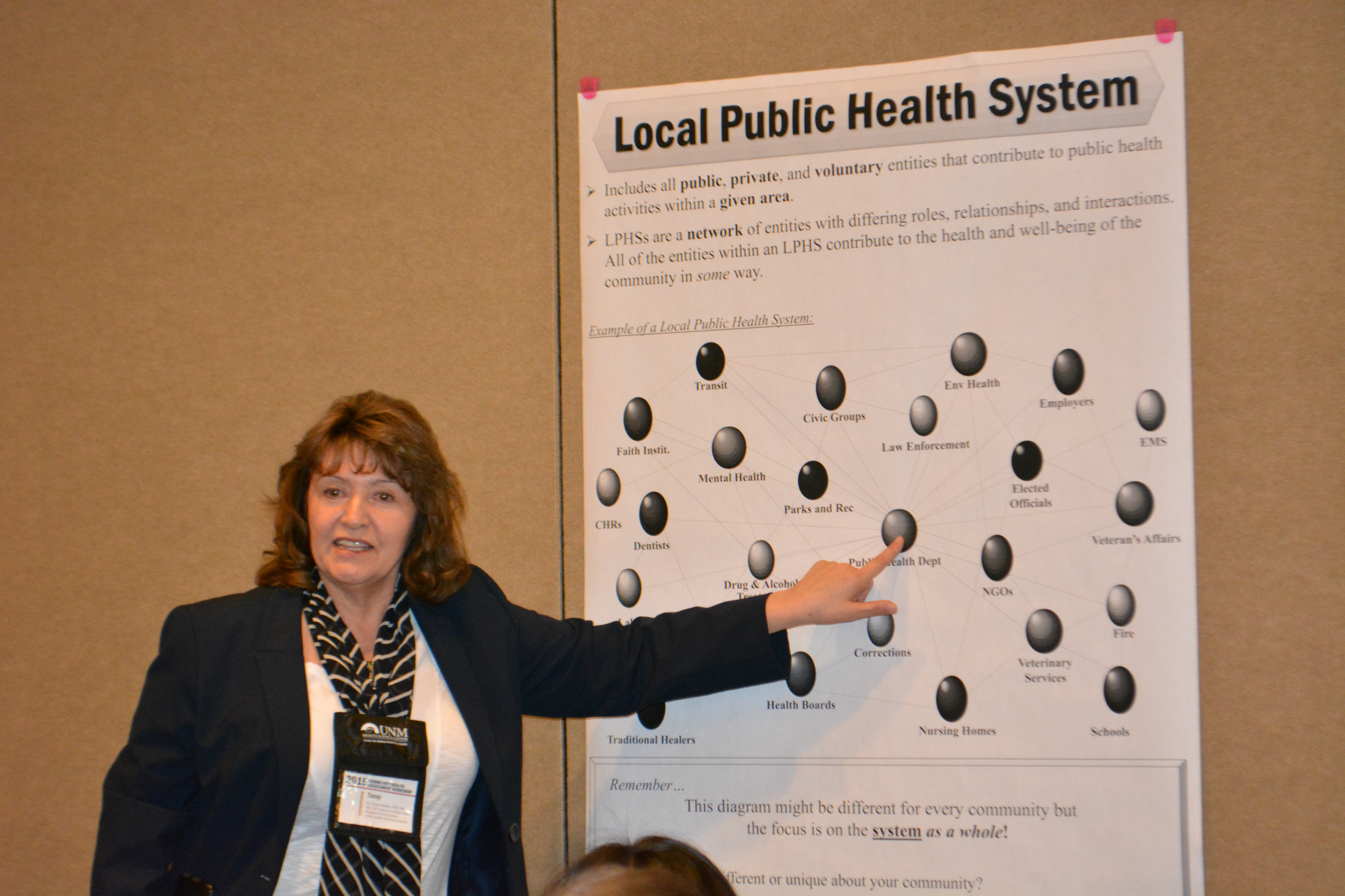 Тасси представляет плакат местной системы общественного здравоохранения.