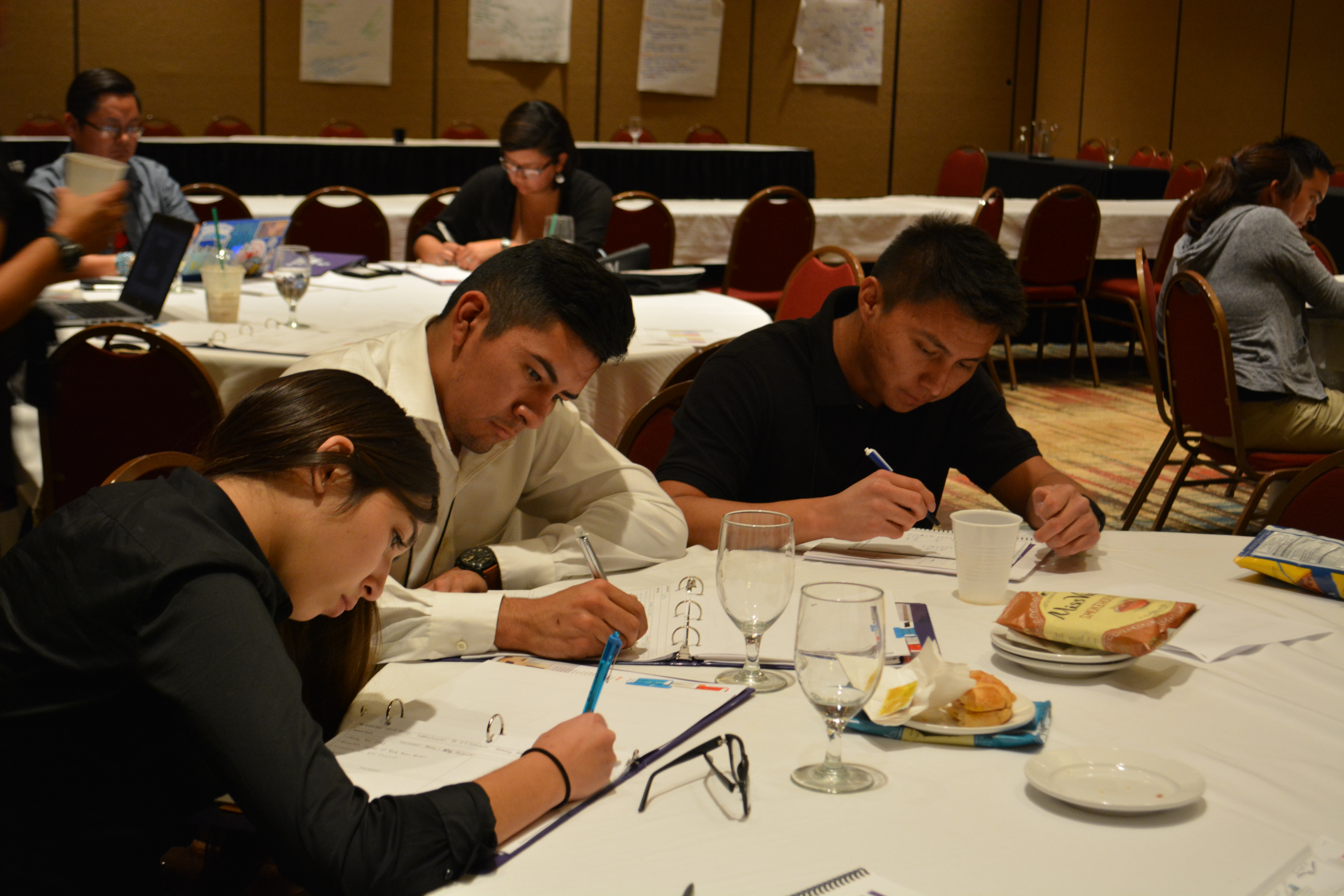 Participantes escribiendo en mesas.