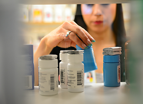 Stock Bild eines Apothekers, der Medikamente greift