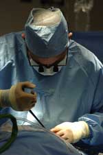 Foto de primer plano de un cirujano masculino con una herramienta quirúrgica en un paciente.