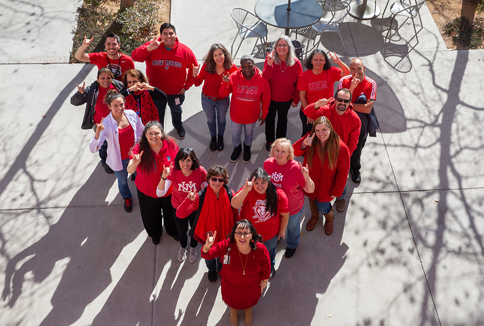 Aerial view of staff standing in a heart wearing red.