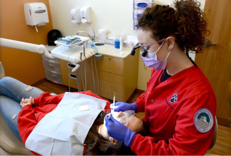 मरीज के दांतों की सफाई करते हाइजीनिस्ट।