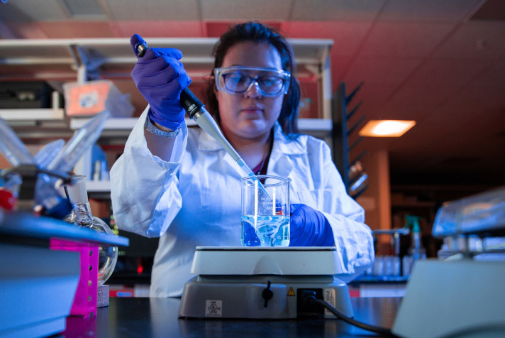 Female student pipetting.