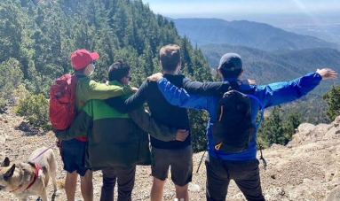 Hikers looking out from the top of a mountain.