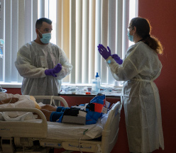 תושבים הלובשים PPE בחדר המטופלים.