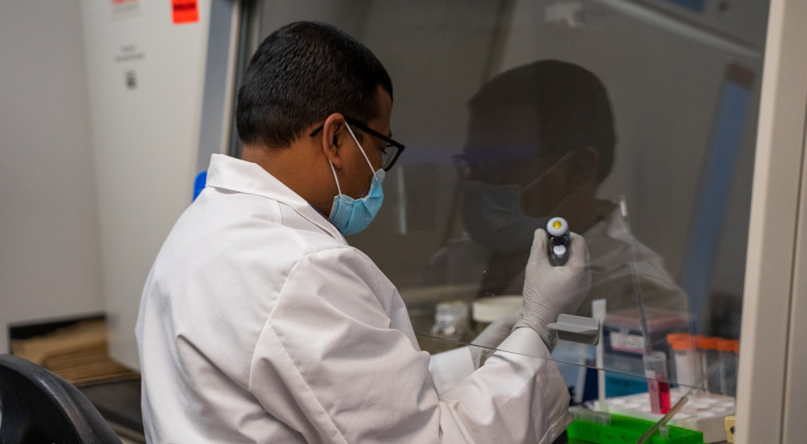 Post Doc Satya Deep working under hood in lab.