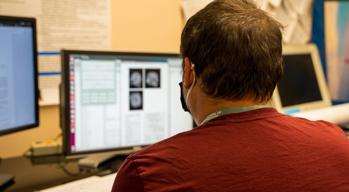 Lab member looking at computer.