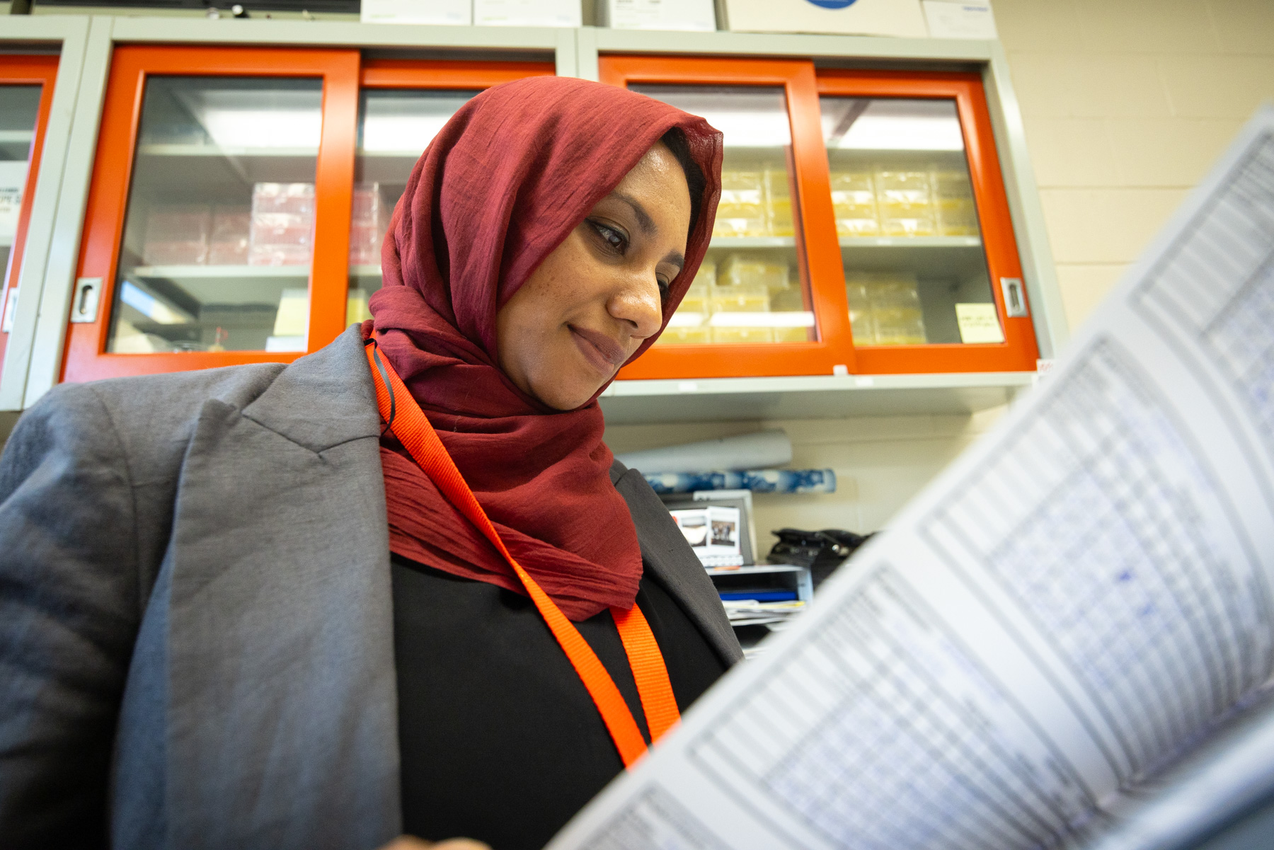 A researcher reading results from a paper in her hand