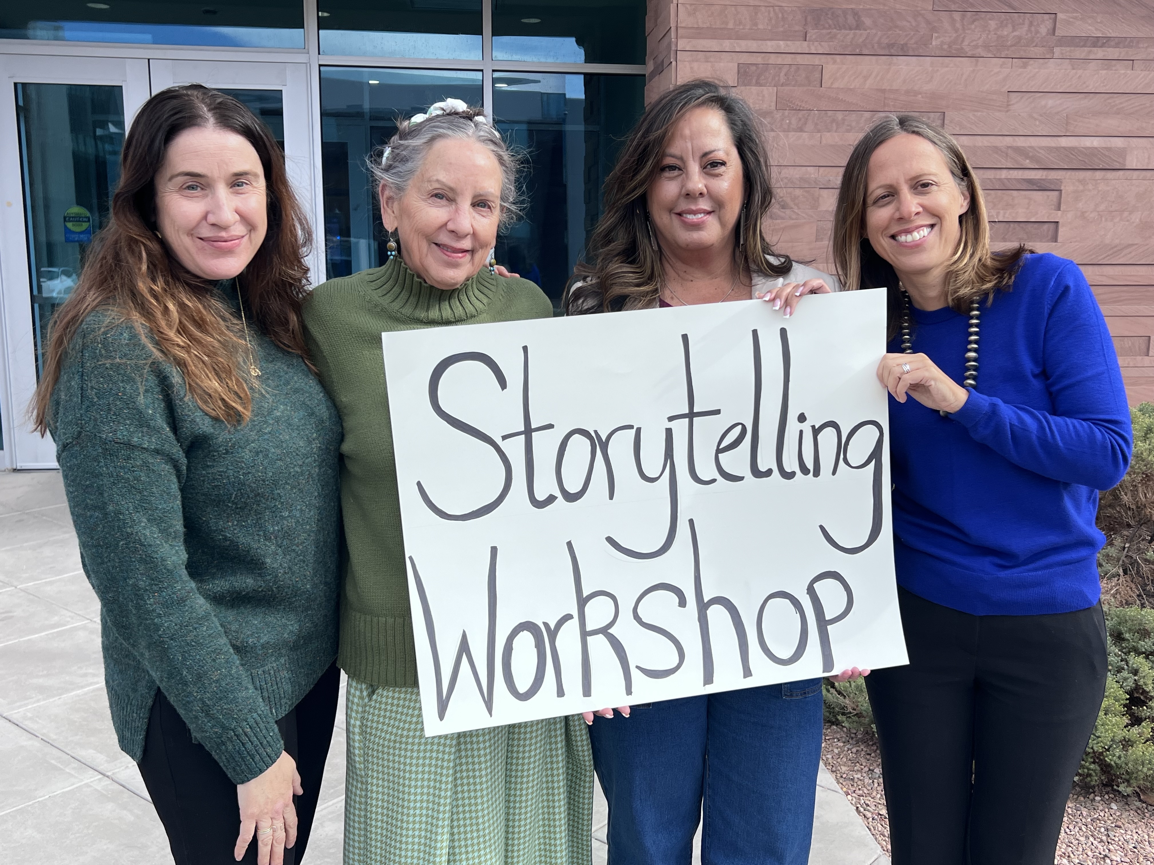 Four staff and faculty holding a sign reading "Storytelling"
