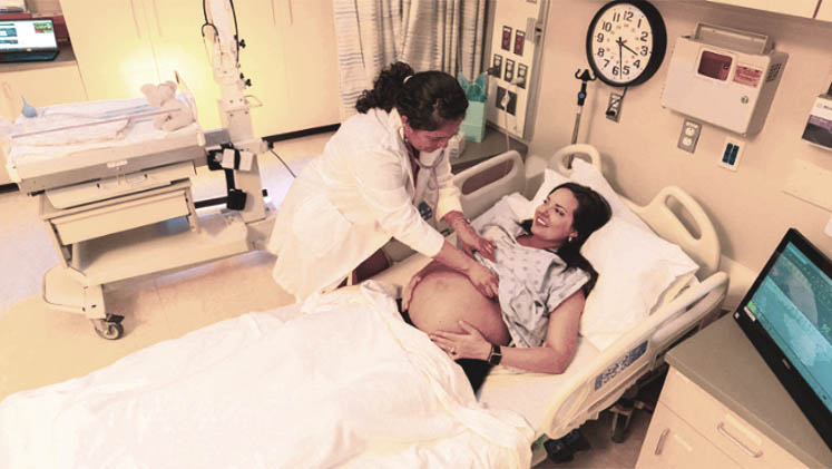 Eine Hebamme, die mit einer schwangeren Mutter arbeitet