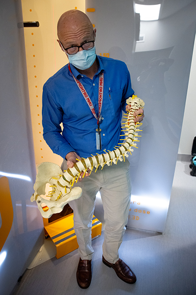 Patrick Bosch, MD, con in mano un modello della colonna vertebrale