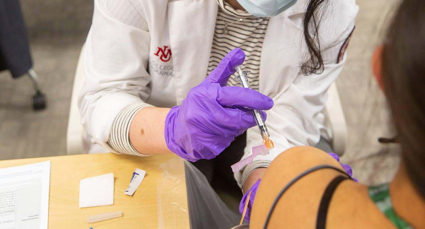 Медицинский работник ЕНД делает кому-то вакцину от COVID-19