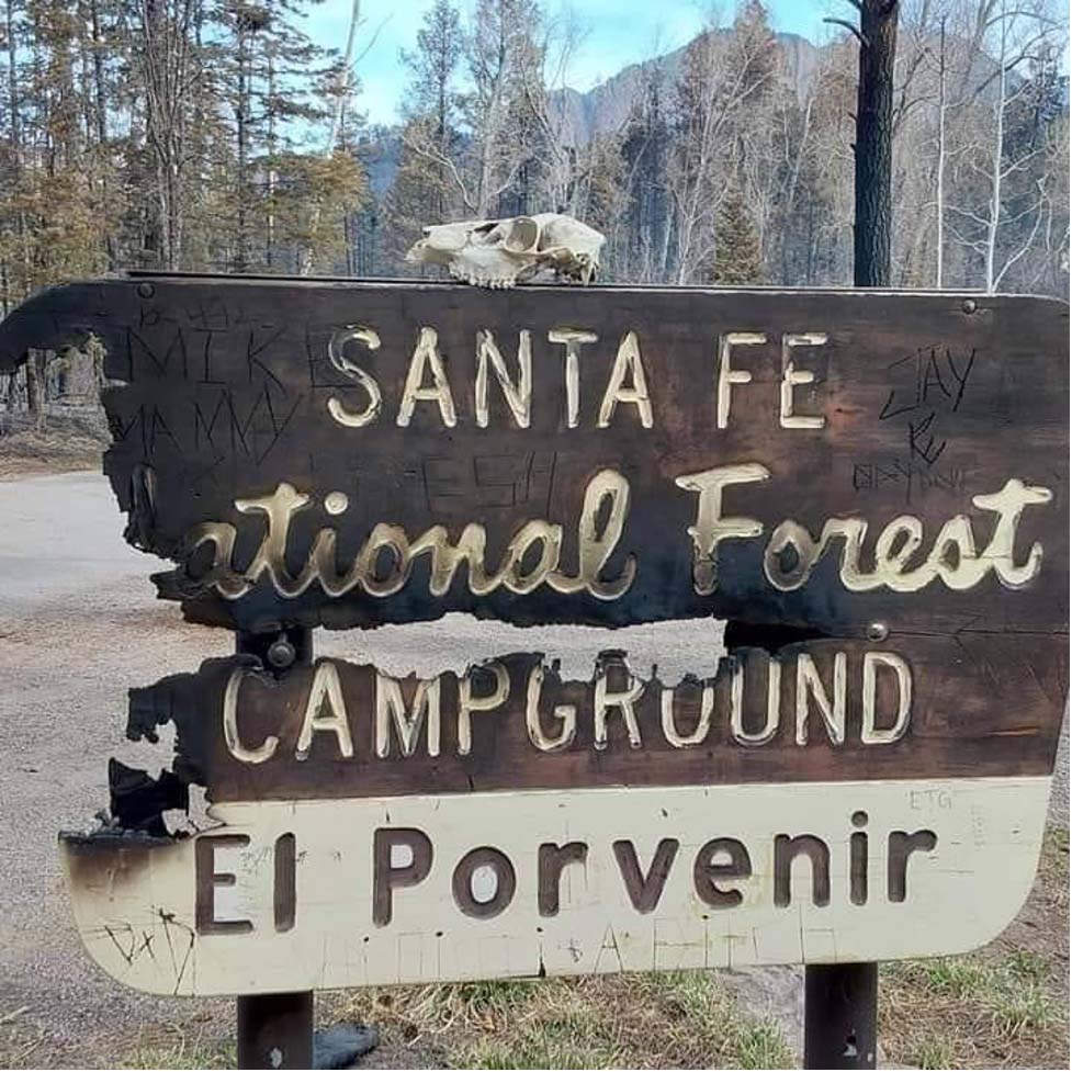The partially burnt sign for El Porvenir campground at Santa Fe National Forest