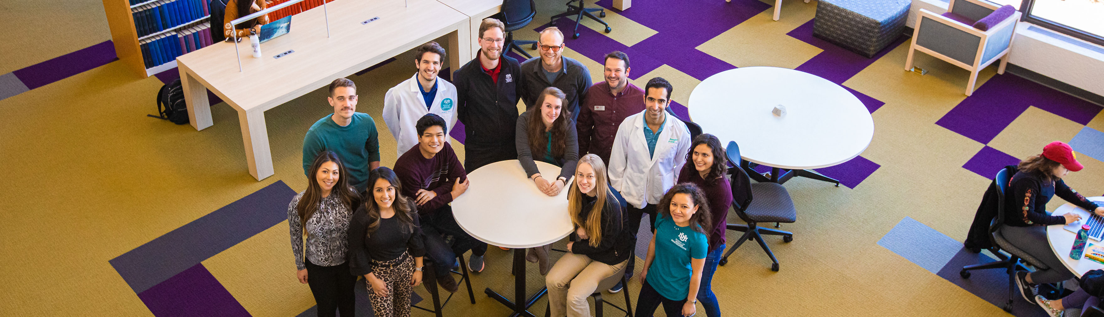 طلاب من العديد من البرامج التعليمية في كلية الطب بجامعة UNM يجتمعون لالتقاط صورة في مكتبة العلوم الصحية