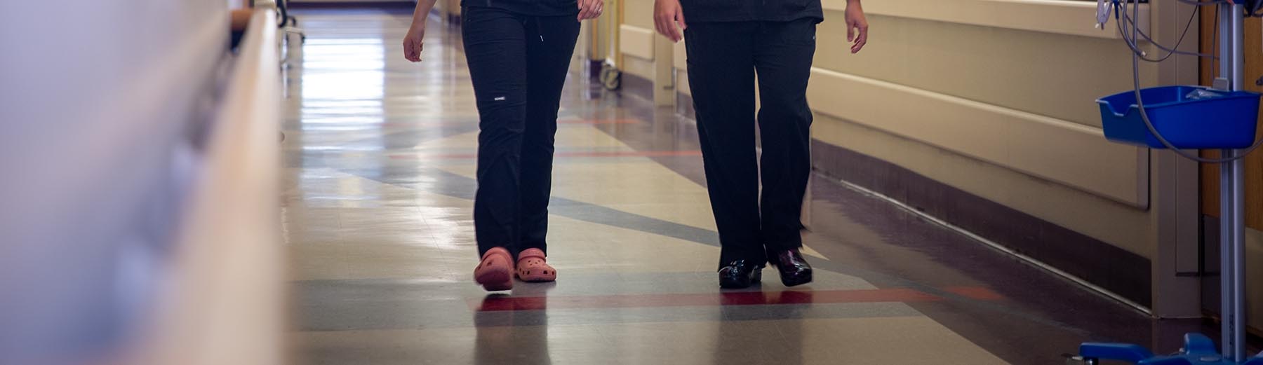 Two nurses walking down a hallway