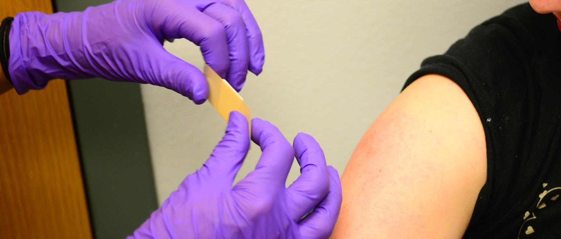 Une personne recevant un pansement d'un prestataire après avoir reçu un vaccin