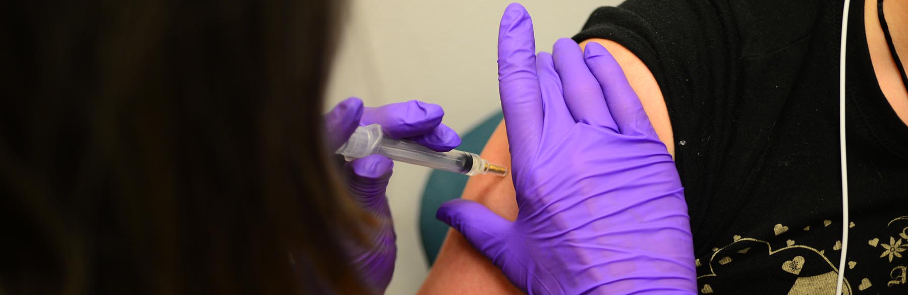 Медицинский работник делает пациенту прививку от вакцины