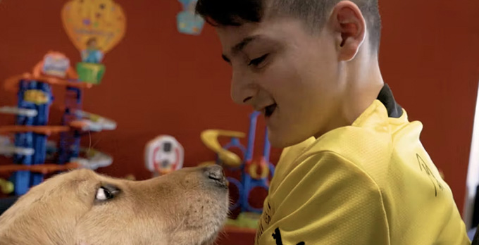 Choco the service dog visits a patient at the UNM Children's Hospital