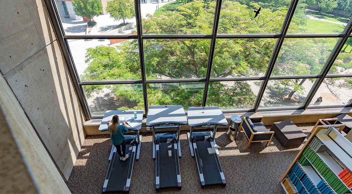 student on treadmill in library
