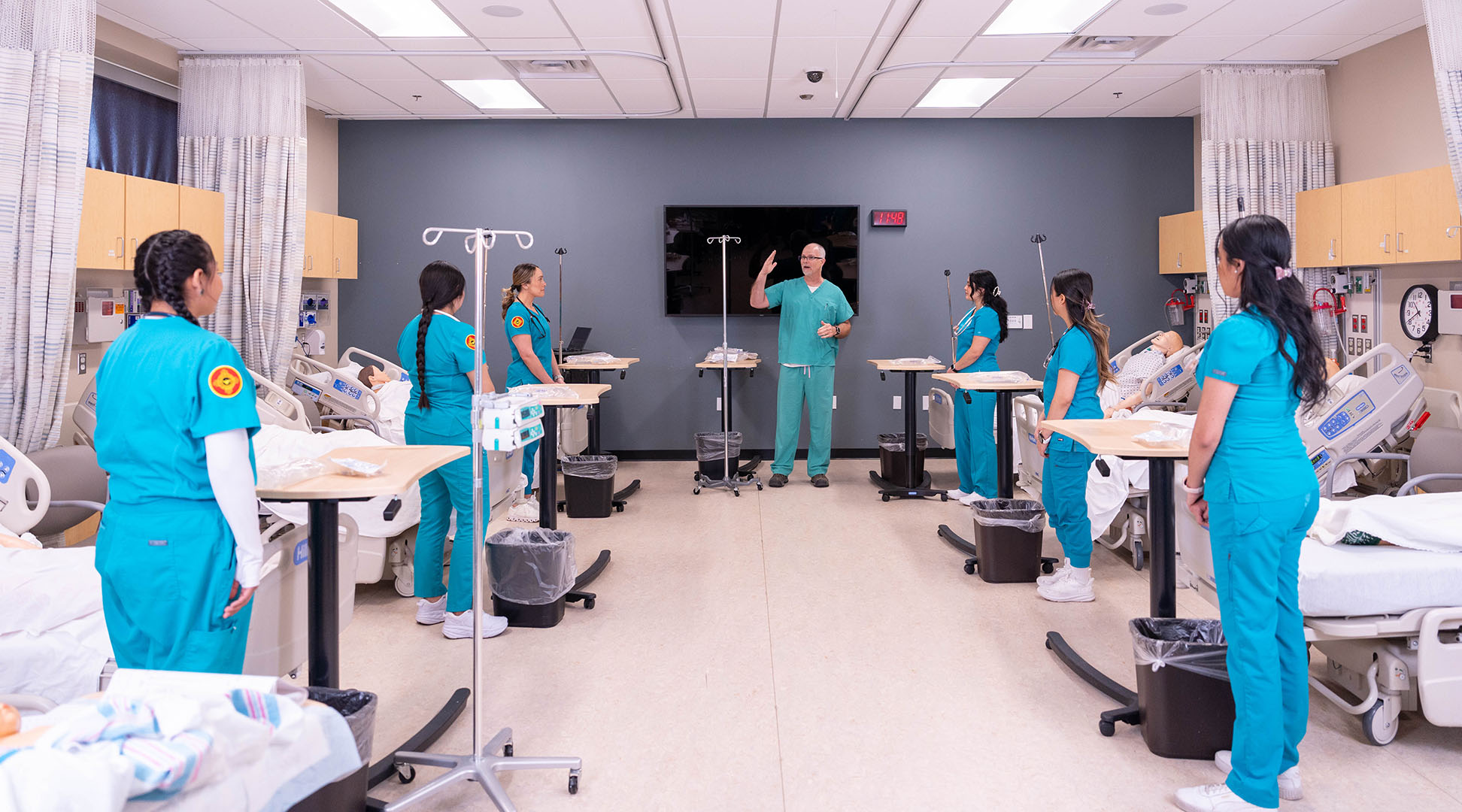 Students and faculty in large sim labs room