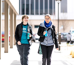 Group of nursing students sitting outside on grass.