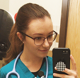 female in scrubs taking a selfie at work
