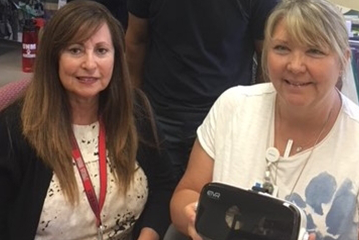 2 women faculty members hold VR glasses