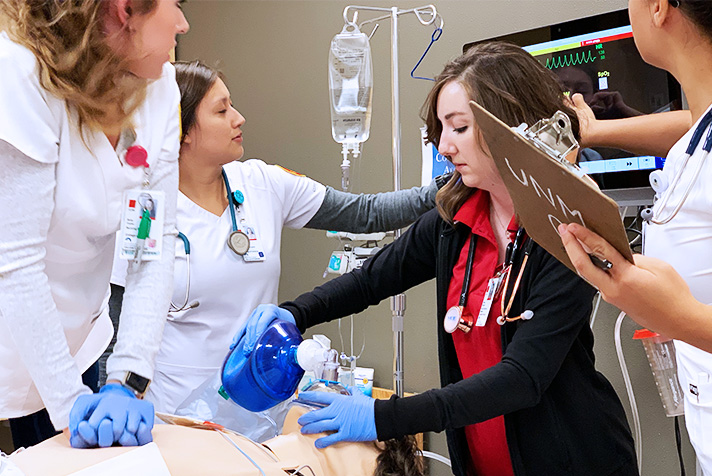 Étudiants en soins infirmiers aprn et bsn travaillant sur un mannequin