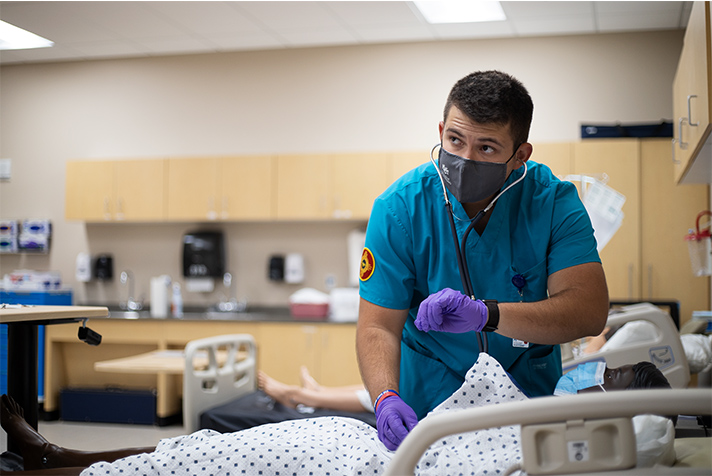 Estudiante masculino con máscara en el laboratorio de simulación