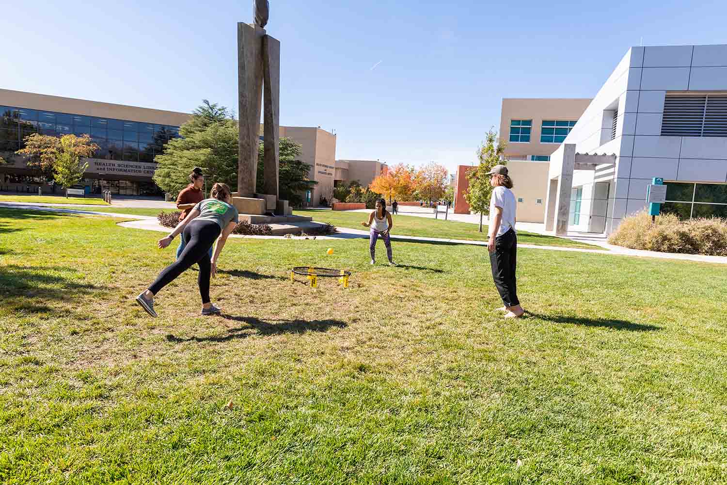 4 students playing a game on the grass.