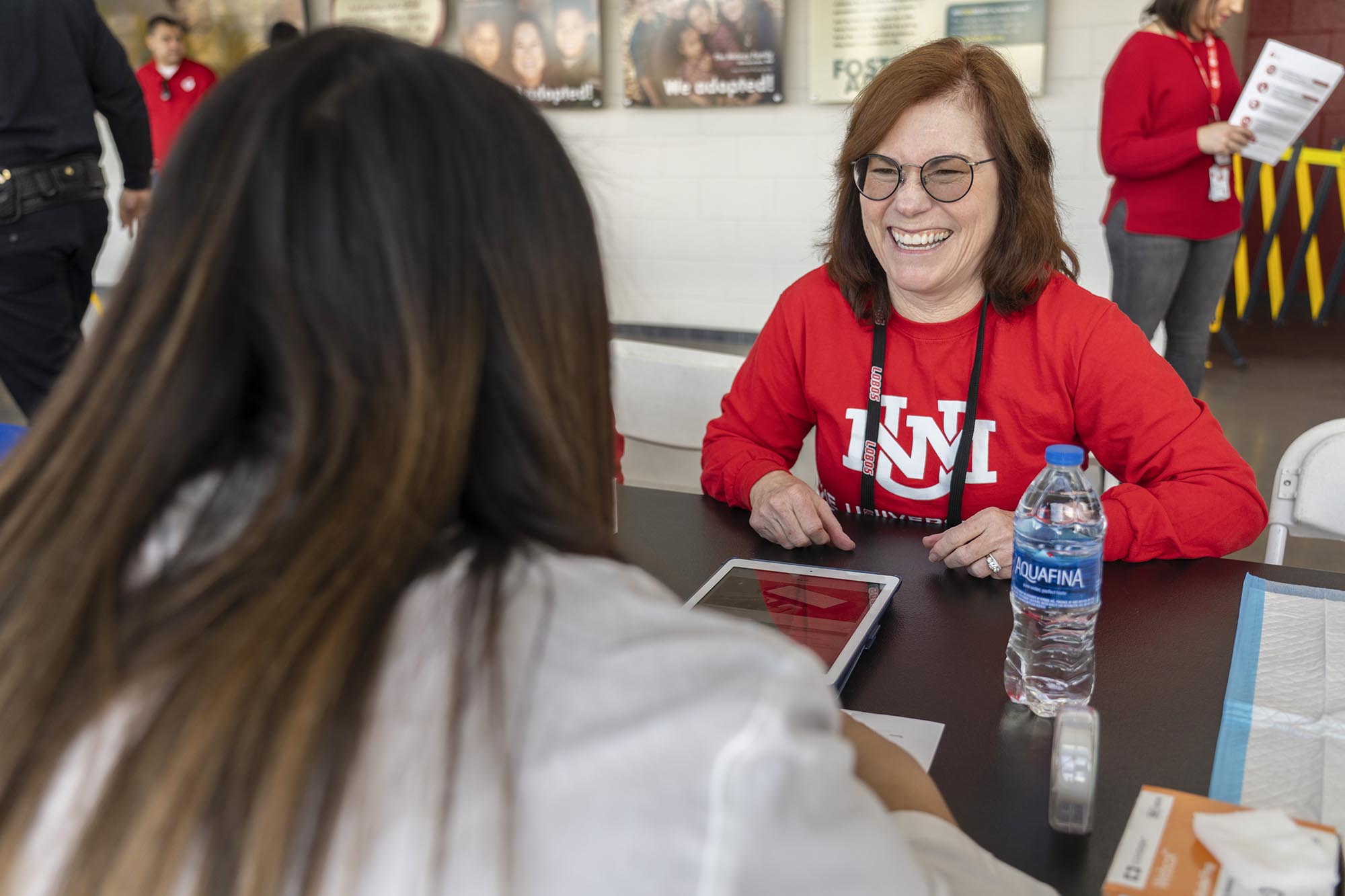 UNM President Garnett Stokes receiving a free health screening from a student pharmacist.