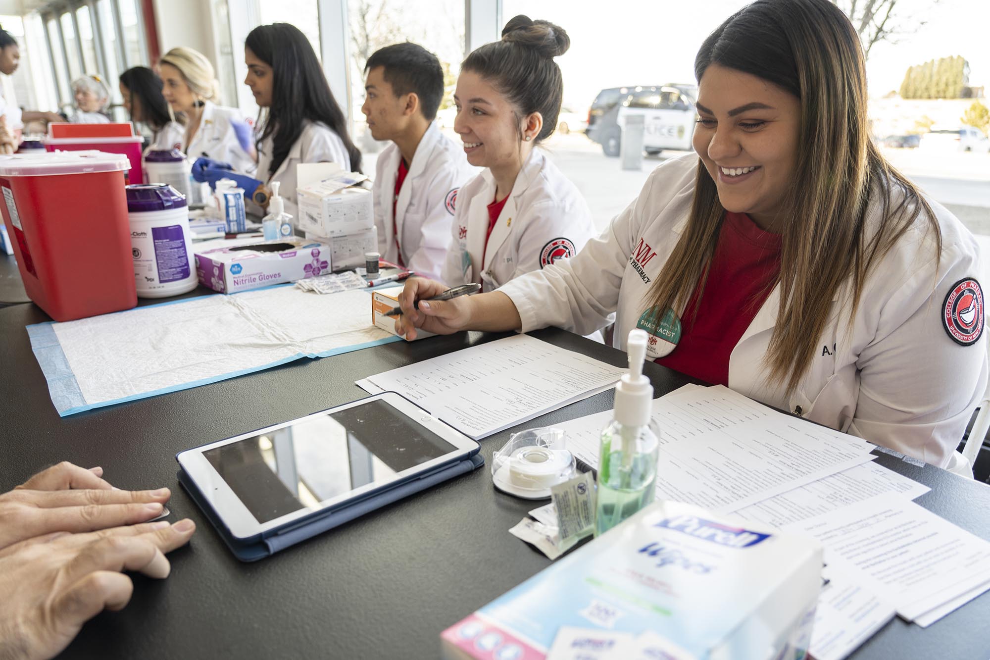 Alunos farmacêuticos realizam exames de saúde gratuitos em um jogo de basquete feminino da Lobo.