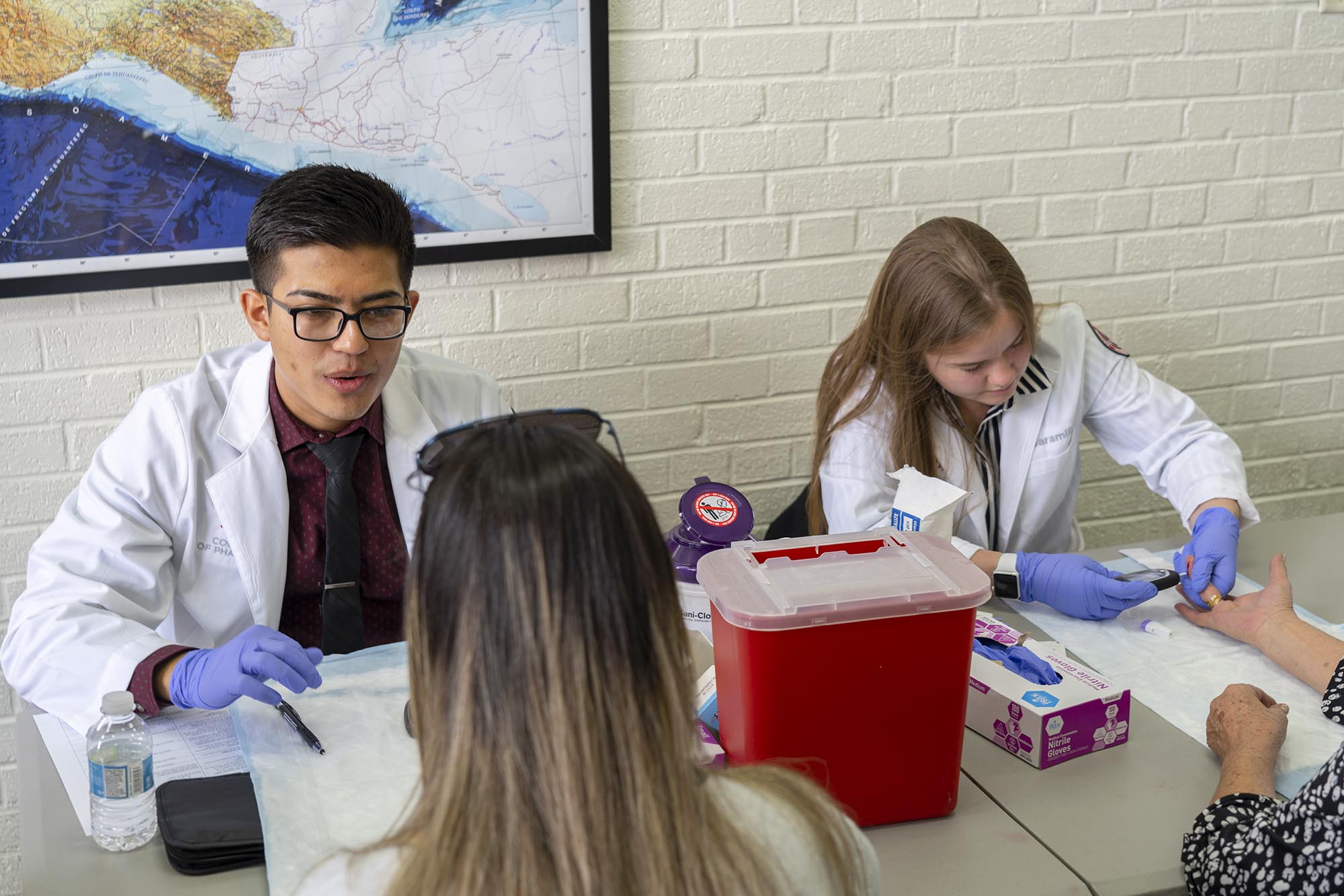 Student pharmacists testing blood glucose levels.