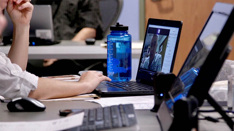 Una persona frente a una computadora portátil.